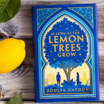The book As Long As the Lemon Trees Grow by Zoulfa Katouh rests on a table with lemons and leaves to the left.