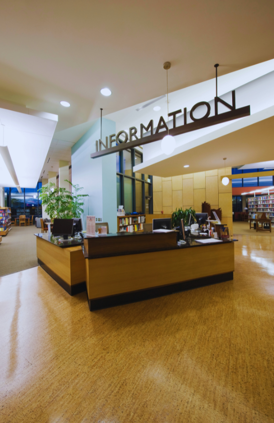 Bureau dans une bibliothèque avec une pancarte indiquant « Information » dessus.