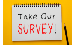The words Take Our Survey! appear written on a white notebook. There is a black pencil beside the notebook,