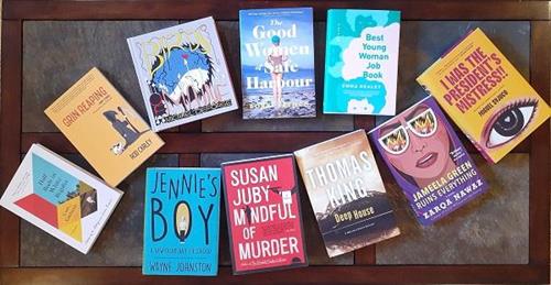 Several books are laid out on a wood surface.