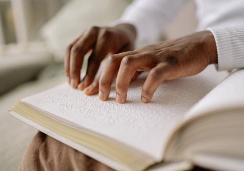 Two hands read braille.