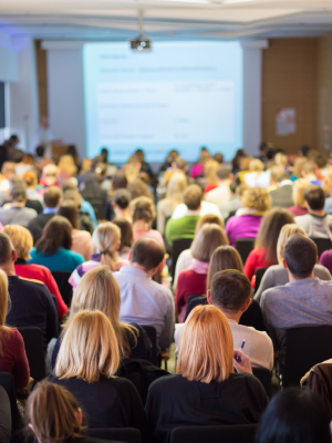a crowd listening to a speaker at a conference.