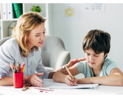 Un adulte et un étudiant travaillent ensemble à un bureau.