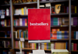 A red sign says "bestsellers" against a backdrop of bookshelves.