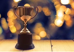 Un trophée se dresse sur un fond étincelant.