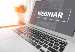 A laptop screen shows the word Webinar.