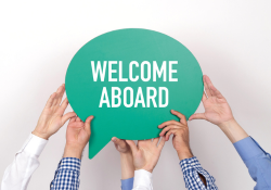 Hands hold up a sign saying Welcome Aboard.