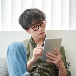 Un jeune homme lit sur une tablette