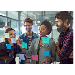 A group of four people rearranging sticky notes on a board.