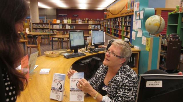 bibliothécaire montrant au patron une brochure CAEB