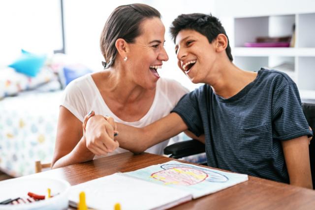 Woman sitting beside teenage boy with a disability