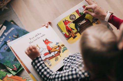 Toddler sitting with printbraille book on lap